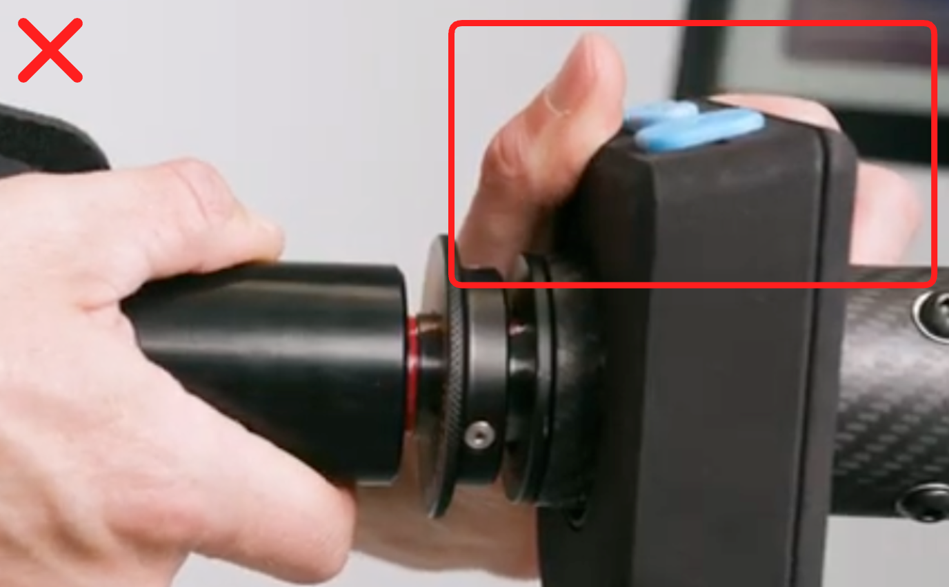 Not this: hand gripping the Bluetooth controller housing, marked with a red X